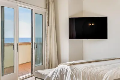 a bedroom with a bed with a television on the wall at Luxury, renovated, oceanfront home with incredible deck & views - dogs welcome in San Diego