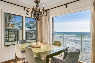 a dining room with a table and a view of the ocean at Luxury, renovated, oceanfront home with incredible deck & views - dogs welcome in San Diego