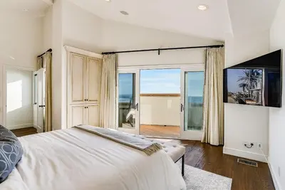 a bedroom with a bed and a view of the ocean at Luxury, renovated, oceanfront home with incredible deck & views - dogs welcome in San Diego