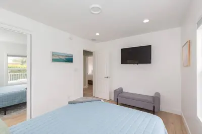 a bedroom with a bed and a tv on the wall at Beach House In The Heart Of PB in San Diego