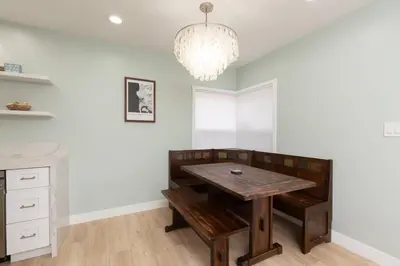 a dining room with a wooden table and a chandelier at Beach House In The Heart Of PB in San Diego