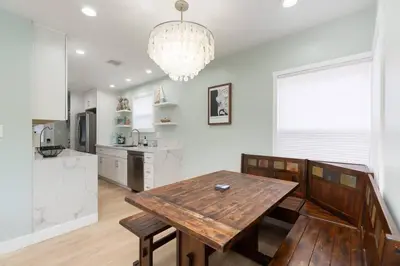 a kitchen with a wooden table and a chandelier at Beach House In The Heart Of PB in San Diego