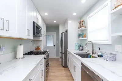 a kitchen with white cabinets and a stainless steel refrigerator at Beach House In The Heart Of PB in San Diego