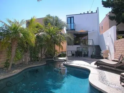 a swimming pool in front of a house with palm trees at Stunning View Mission Bay Luxury Home Private Pool in San Diego