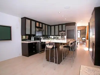 a kitchen with black cabinets and bar stools at Stunning View Mission Bay Luxury Home Private Pool in San Diego