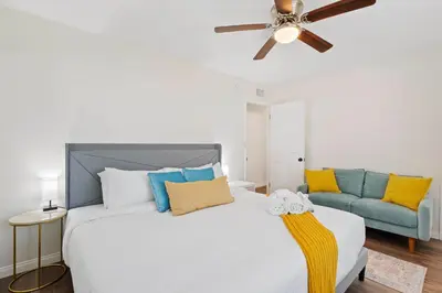 a bedroom with a white bed and a blue couch at Sweet Escape - Family Retreat - Vibrant - Spa in San Diego