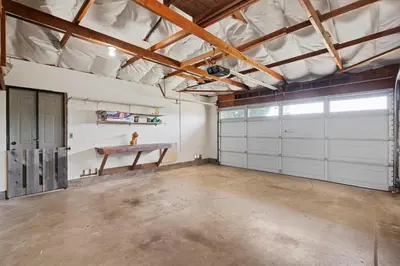 an empty garage with white garage doors and a table at Sweet Escape - Family Retreat - Vibrant - Spa in San Diego