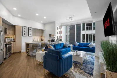 a living room with blue couches and a kitchen at Park Lux PlayHouse in San Diego