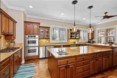 a large kitchen with wooden cabinets and stainless steel appliances at Temecula Wine Country Villa in Temecula