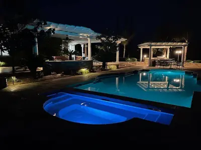 a blue swimming pool in a yard at night at Temecula Wine Country Villa in Temecula