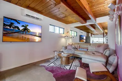 a living room with a couch and a tv on the wall at Avoyer One Bedroom Guesthouse - La Mesa in La Mesa