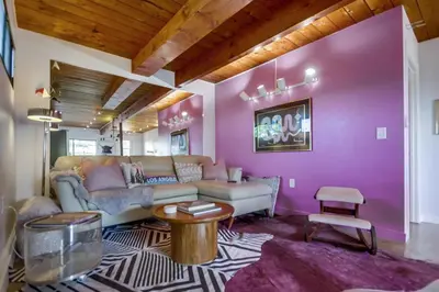 a living room with a couch and a pink wall at Avoyer One Bedroom Guesthouse - La Mesa in La Mesa