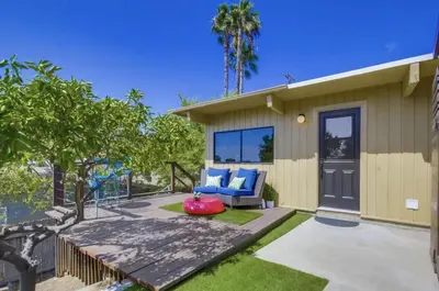 a home with a patio with a blue couch and trees at Avoyer One Bedroom Guesthouse - La Mesa in La Mesa