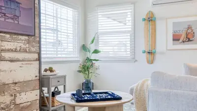 a living room with a table and a chair at Surfrider I by AvantStay Walk to the Beach Patio in Newport Beach