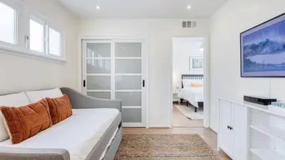 a living room with a couch and a tv at Surfrider I by AvantStay Walk to the Beach Patio in Newport Beach