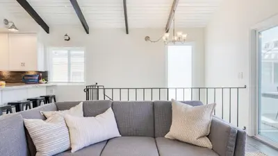 a living room with a couch and a kitchen at Surfrider II by AvantStay Walk to the Beach Balcony in Newport Beach