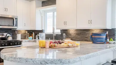a kitchen counter with a cutting board of fruit on it at Surfrider II by AvantStay Walk to the Beach Balcony in Newport Beach