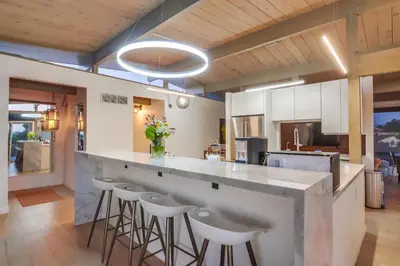 a kitchen with a large counter with stools at The Helix House - Pool & Mountain Views in La Mesa