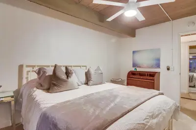 a bedroom with a large white bed and a tv at The Helix House - Pool & Mountain Views in La Mesa