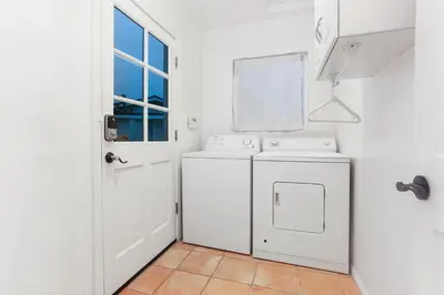 a white laundry room with a washer and dryer at La Playa - Charming Bayside Bungalow in San Diego