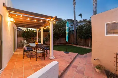 a patio with a table and chairs under a pergola at La Playa - Charming Bayside Bungalow in San Diego