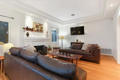 a living room with a leather couch and a table at La Playa - Charming Bayside Bungalow in San Diego