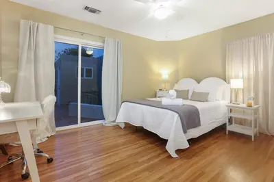 a bedroom with a bed and a desk and a window at La Playa - Charming Bayside Bungalow in San Diego