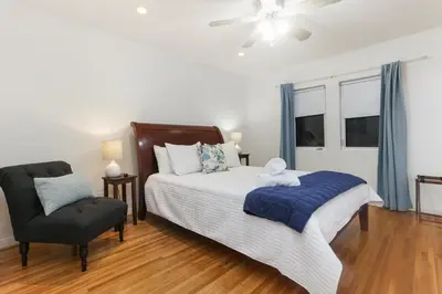 a bedroom with a bed and a chair at La Playa - Charming Bayside Bungalow in San Diego