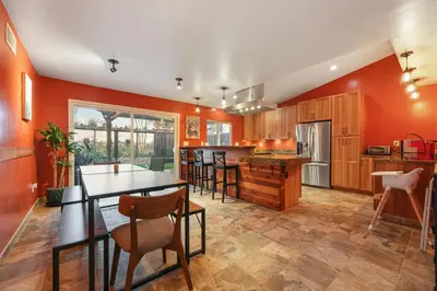 a kitchen with orange walls and a table and chairs at Canyon Breeze - Private Home with Hot Tub & Views in San Diego