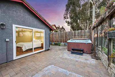 a backyard with a bed and a tub and a fence at Canyon Breeze - Private Home with Hot Tub & Views in San Diego