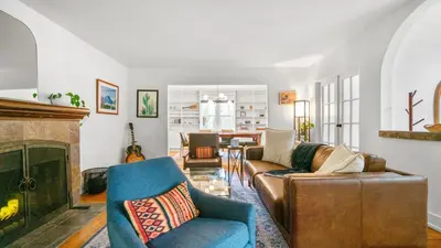 a living room with a couch and a fireplace at Chic Kensington Home - Hot Tub & Canyon Views in San Diego