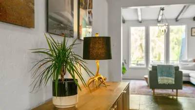 a living room with a table with a plant on it at Chic Kensington Home - Hot Tub & Canyon Views in San Diego