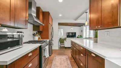 a kitchen with wooden cabinets and white counter tops at Chic Kensington Home - Hot Tub & Canyon Views in San Diego