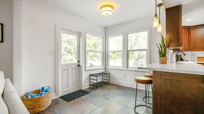 a kitchen with white walls and windows and a counter at Chic Kensington Home - Hot Tub & Canyon Views in San Diego