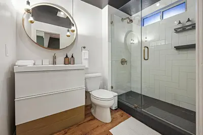 a bathroom with a toilet and a glass shower at Agua Dulce - Mid Century Oasis - Pool &Hot Tub in Spring Valley