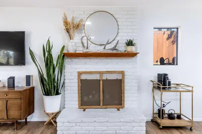 a living room with a fireplace with a mirror at Echo by Coast to Cactus - Family-Friendly Home in La Mesa