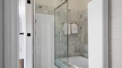 a shower with a glass door in a bathroom at The Oliver - Pacific Beach Hideaway in San Diego