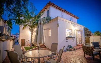 a table with an umbrella in front of a house at Mediterranean-Style Villa in Point Loma in San Diego