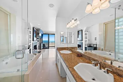 a large bathroom with two sinks and two mirrors at 3 Story Oceanfront Home with Jacuzzi in Newport Beach on the Sand! in Newport Beach