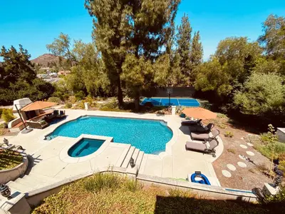 an overhead view of a swimming pool with chairs and trees at Luxury Home with Heated Pool - Spa and Lighted Pickle Ball Court in San Diego