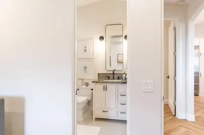 a white bathroom with a toilet and a sink at Enchanting Encinitas Oceanview Casita in Encinitas