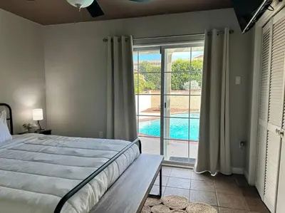 a bedroom with a bed and a view of a pool at HC Accessible 4 Bed 3 Bath with Sparkling Pool and Spa-we have lifts and roll in shower in Santee