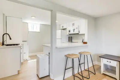 a kitchen with white cabinets and stools in a room at San Diego Apartment with Patio - Near Balboa Park! in San Diego