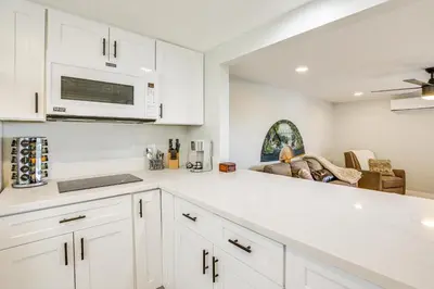 a kitchen with white cabinets and a microwave at San Diego Apartment with Patio - Near Balboa Park! in San Diego