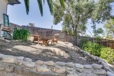 a wooden picnic table in a backyard with a fence at San Diego Apartment with Patio - Near Balboa Park! in San Diego