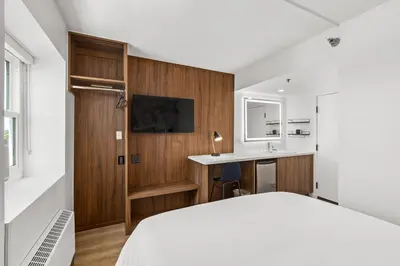 a bedroom with a bed and a desk and a sink at Uptown Inn - Limited Service Apart-Hotel in San Diego