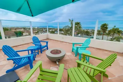 a patio with chairs and a table and an umbrella at Ocean & Bay Views Pool & Hot Tub Rooftop Patio in San Diego