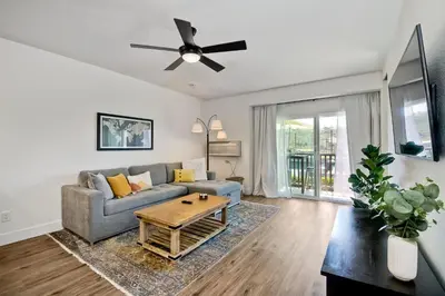 a living room with a couch and a table at Beautifully Remodeled - Private Balcony - Pool View - BBQ Access - Gated Reserved Parking in Encinitas