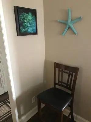 a room with a chair and a starfish on the wall at Laguna Condo w/ Pool/Jacuzzi and Attached Garage in Laguna Niguel