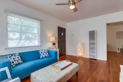 a living room with a blue couch and a table at California Cottage near SDSU in San Diego